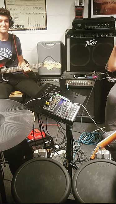 Callum Garland teaching guitar and playing in a band at Musicland East